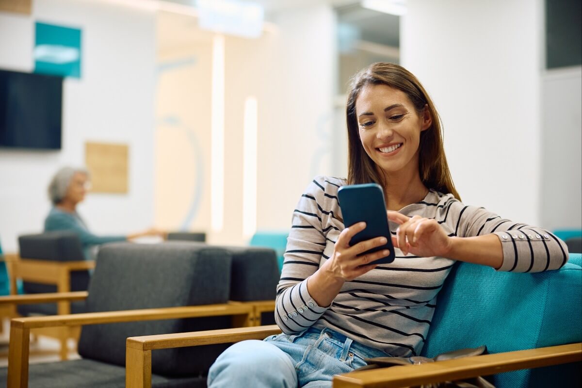 happy patient texting in waiting room