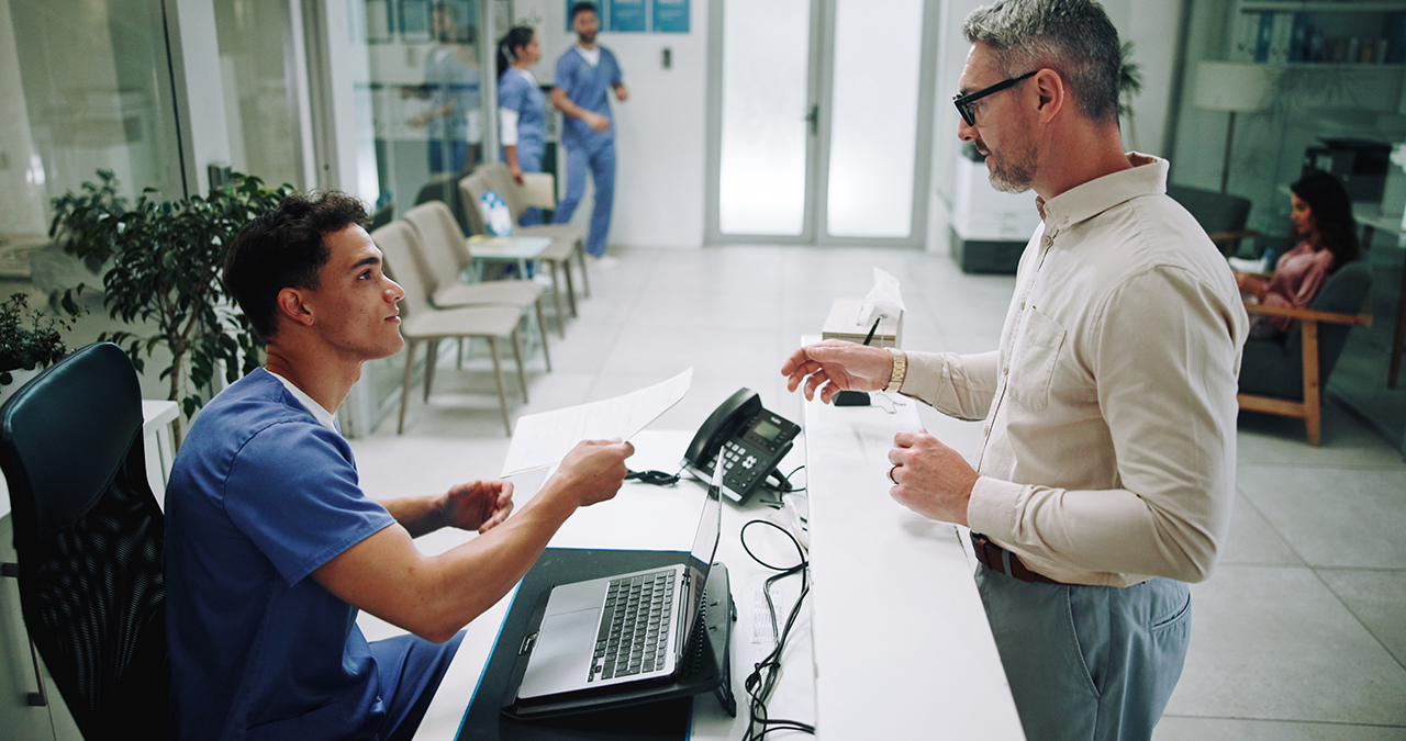 Patient receiving their treatment plan at the front desk at a medical office.