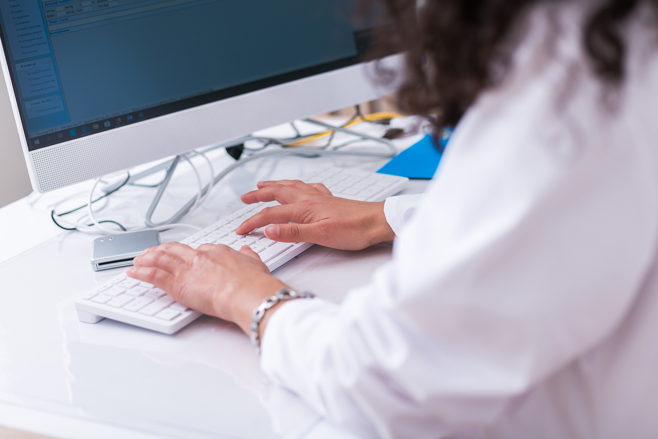 Healthcare staff member using scheduling software as Solutionreach Virtual Scheduling Assistant automates appointment booking and helps the practice manage patient scheduling more efficiently.
