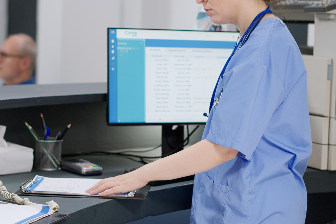 Front desk receptionist assisting patient at check-in image