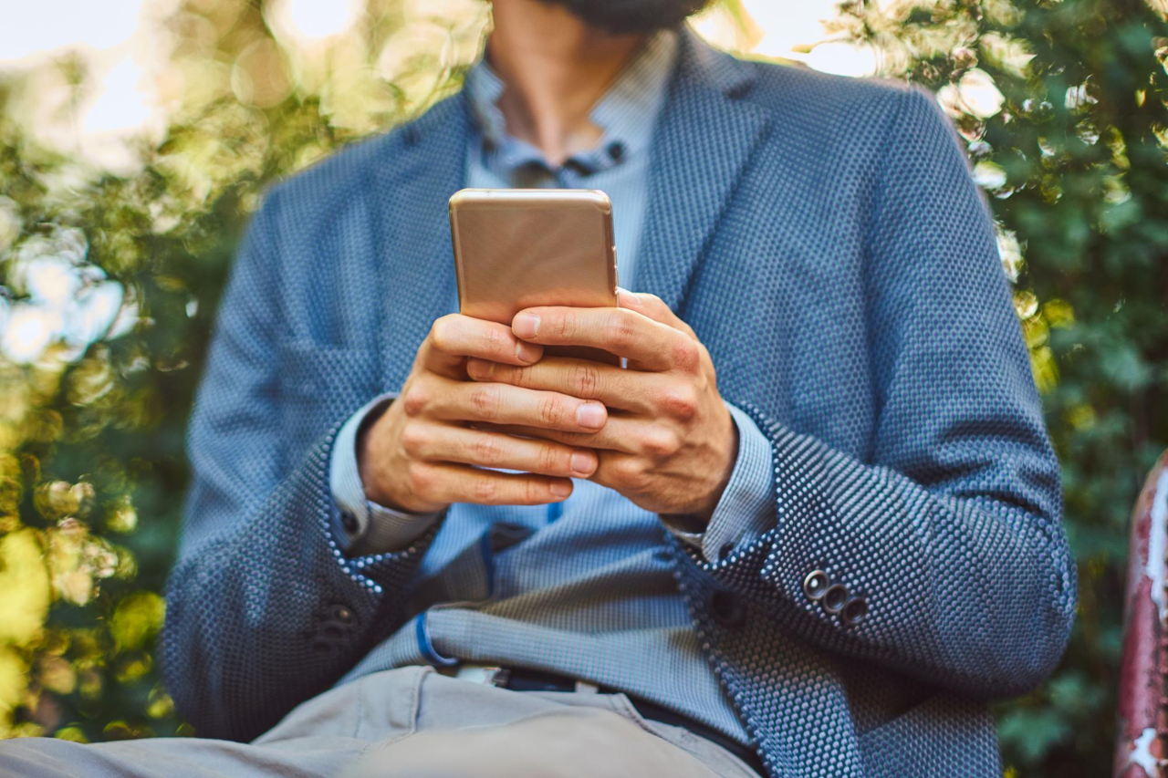 patient conveniently texting healthcare practice from a park bench image