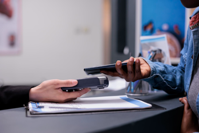patient conveniently paying healthcare practice bill at the front desk using their phone image